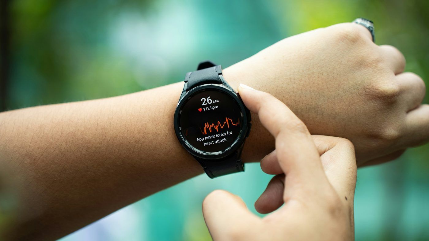 Poignet portant une montre ronde dont l'écran affiche une courbe, doigt sur le bouton