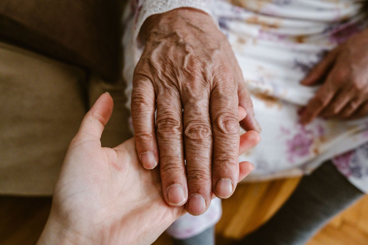 Main âgée posée dans la main d'une personne plus jeune