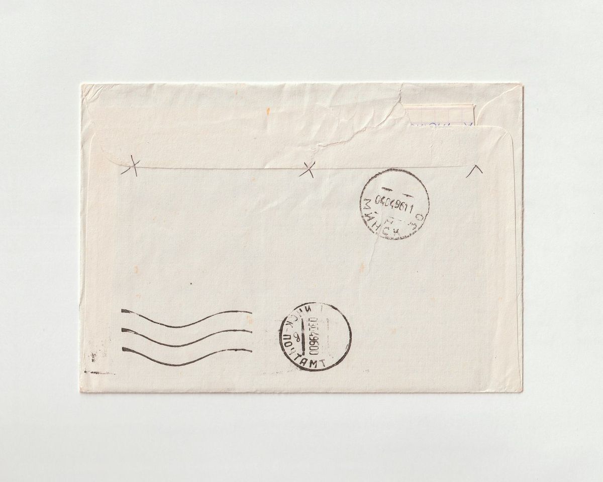 Enveloppe claire portant des cachets postaux, sur fond blanc