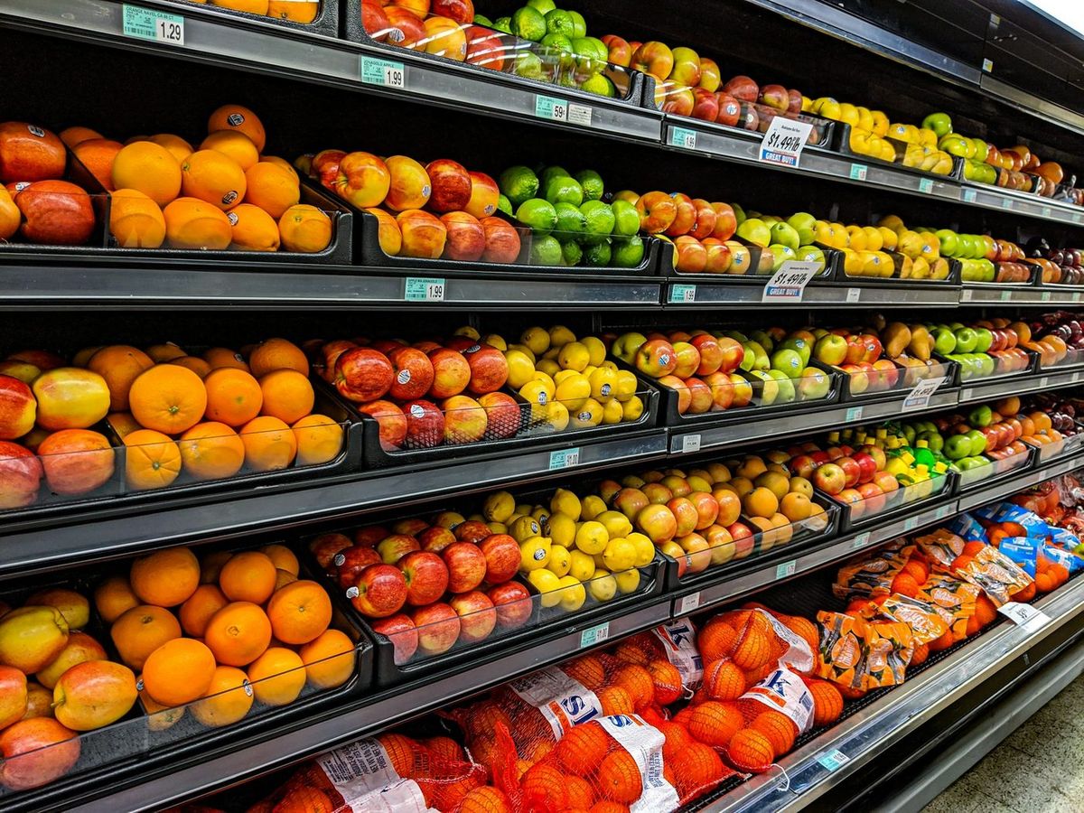 Rayon de fruits frais en vrac dans un magasin, oranges et pommes